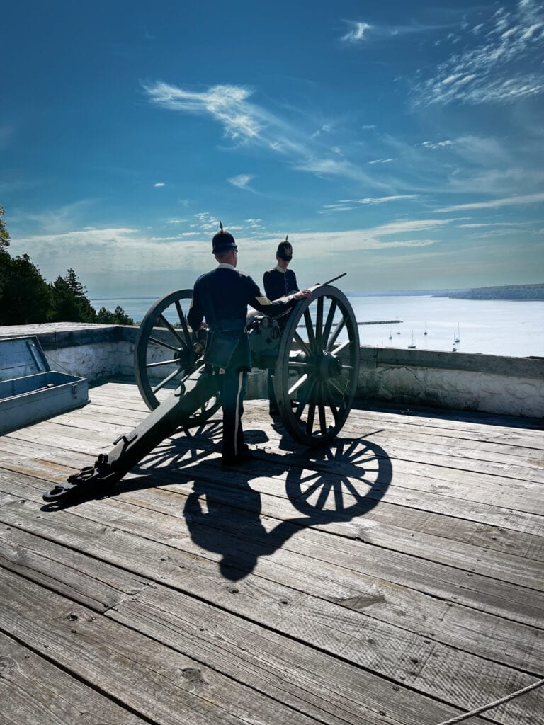 Dressed up military soldiers firing a cannon at Fort Mackinac on Mackinac Island.