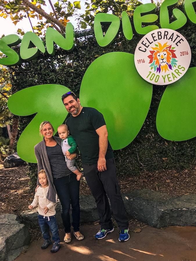 Family in front of sign for the San Diego Zoo.