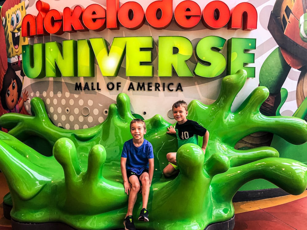 Two boys sitting on a statue of slime at Nickelodeon Universe