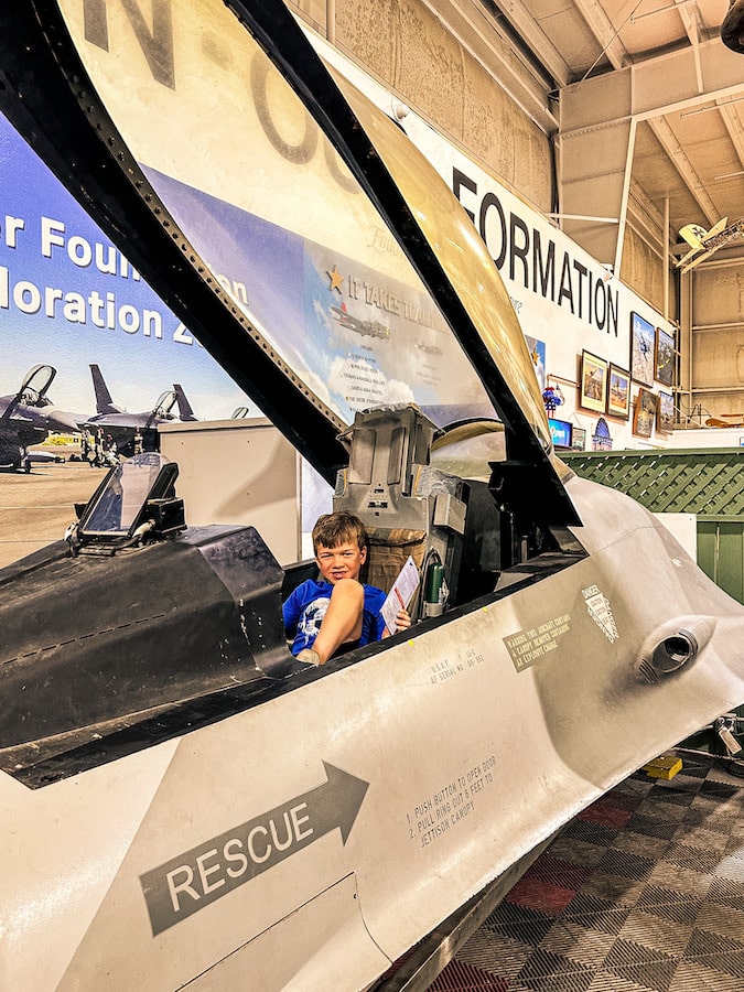 Boy sitting inside of a fake aircraft