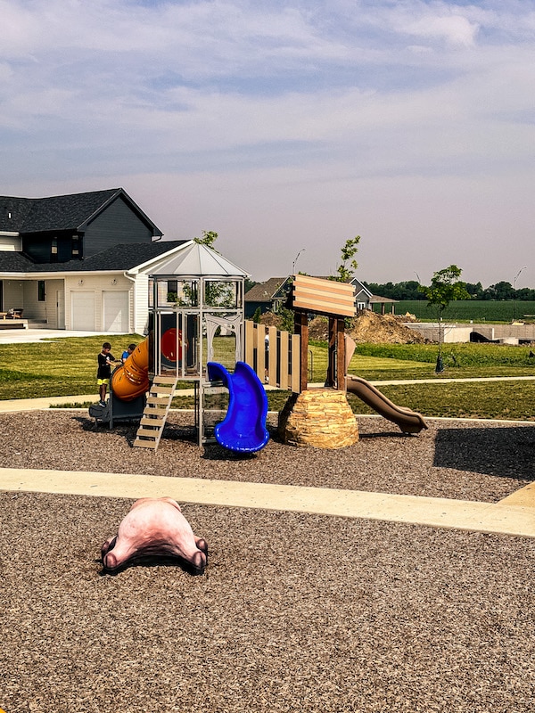 Playground for younger kids that looks like a silo and has a blue slide.