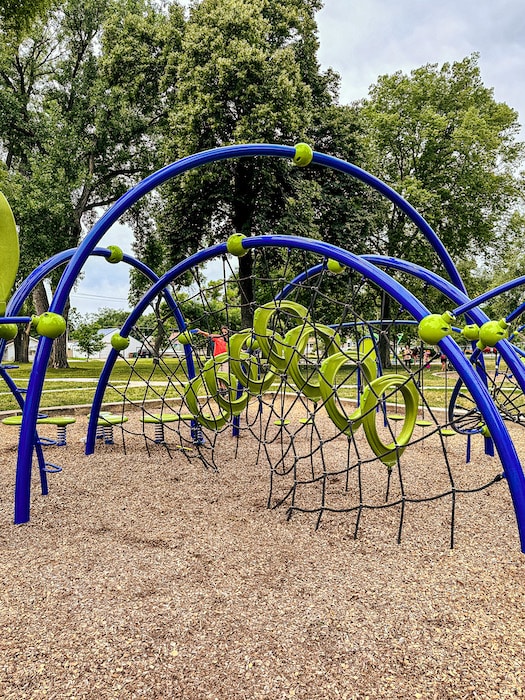 Blue and neon green playground structure with various climbing elements and obstacles.