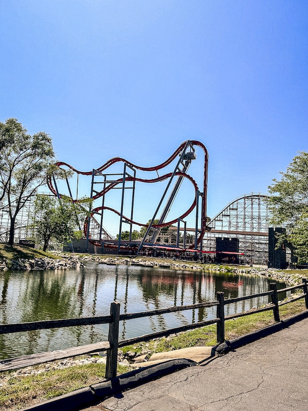 Dragon Slayer roller coaster at Adventureland in the background with a pond in the foreground.