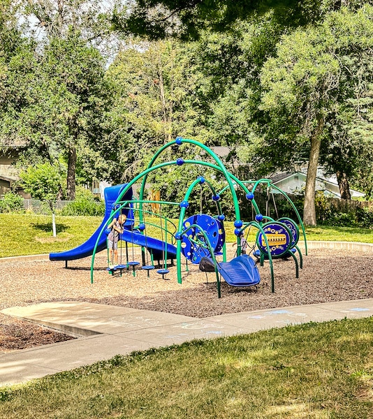 Smaller blue and green playground for younger kids with a small slide.