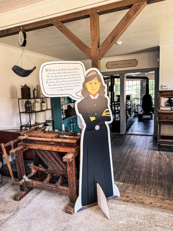 Cardboard cutout of the wife of a general store owner in the general store at the Pella Historical Village