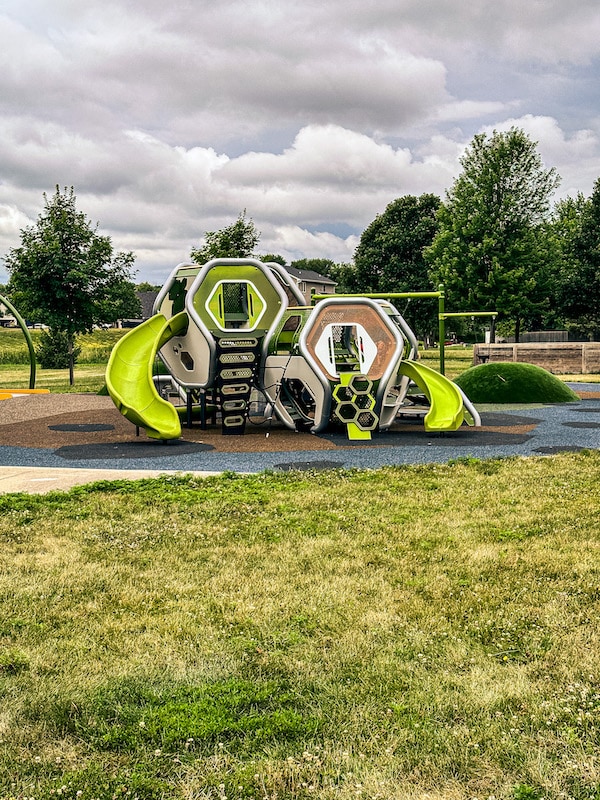Play structure for younger kids that is neon green and brown and made of many shapes.