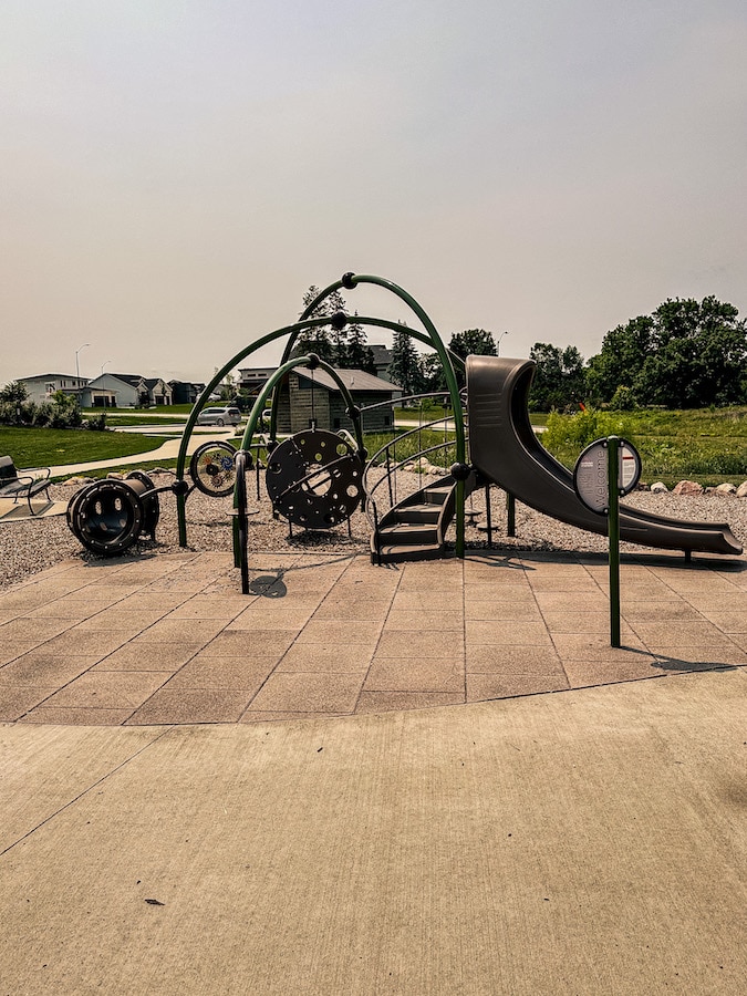 Playground for younger kids at Whisper Point Park with a slide, tunnel, and some climbing structures.