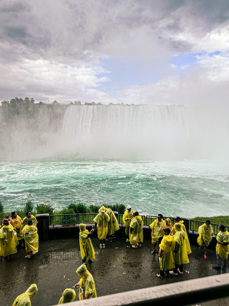 Visitors at Journey Behind the Falls wearing yellow ponchos with Horseshoe Falls in the background.