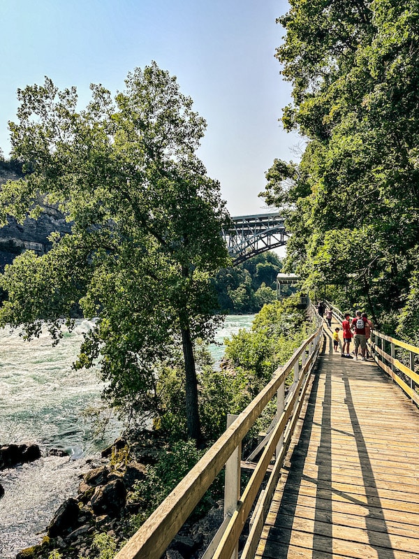 View of people walking on the boardwalk and the Niagara River at Niagara's White Water Walk.