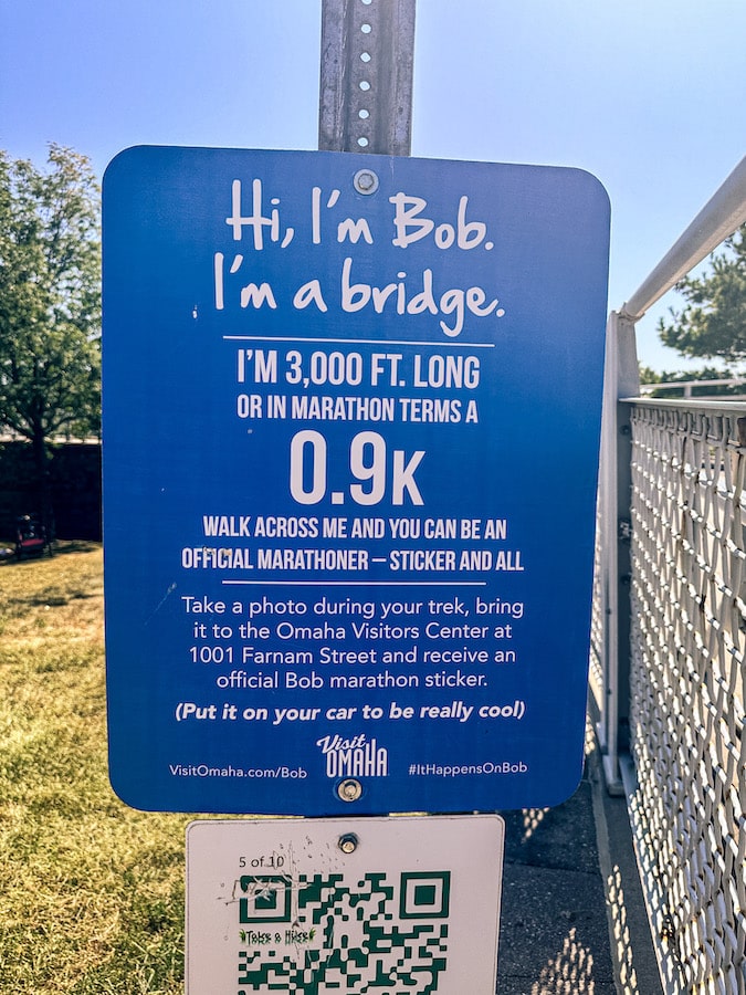 Blue sign saying Hi, I'm Bob. I'm a Bridge and other information about the Bob Kerrey Pedestrian Bridge.