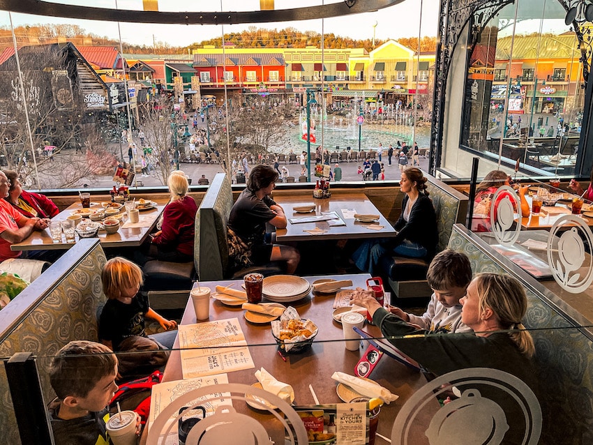 A family dining at Paula Deen's restaurant with a view of the fountain show outside of the window at the Island in Pigeon Forge.