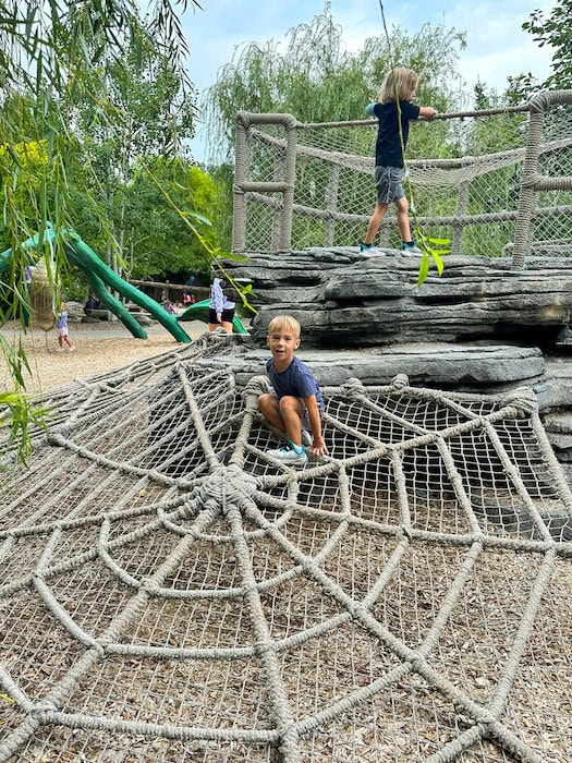 Two young boys play on a giant rope spiderweb structure at the Bay Family Children’s Adventure Trails in Omaha’s Henry Doorly Zoo.