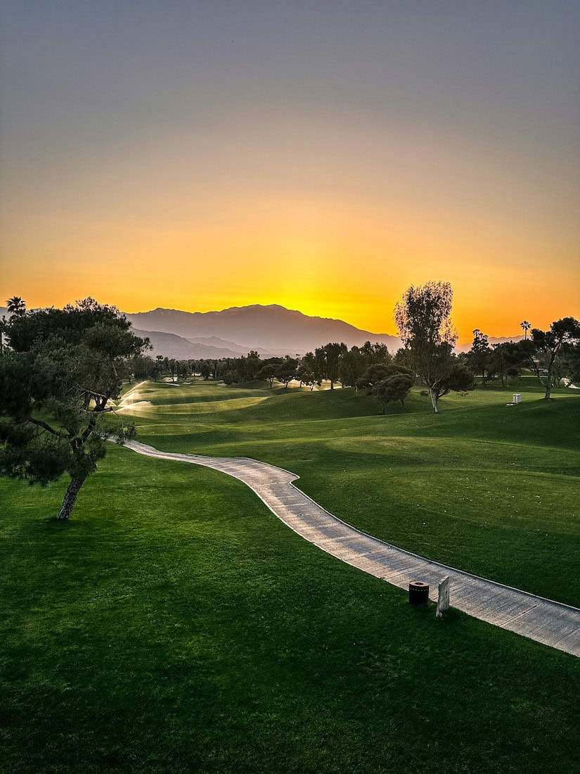 Golf course and path with sun setting behind the mountains