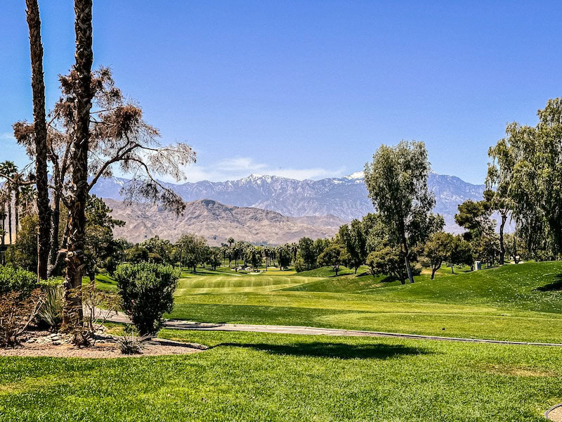 Golf course with view of mountains and blue sky