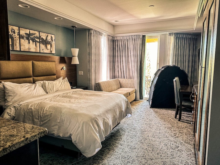 Bedroom with a king size bed, pull out sofa, and a Slumberpod tent pictured.