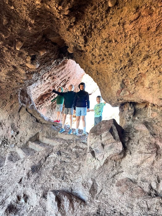 Kids standing inside of Hole in the Rock at Papago Park in Phoenix, Arizona.