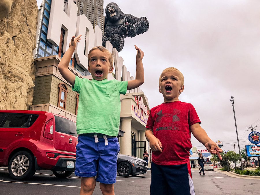 Two young boys reacting excitedly to the giant King Kong statue hanging off the side of a building along the Branson Strip in Branson, Missouri.