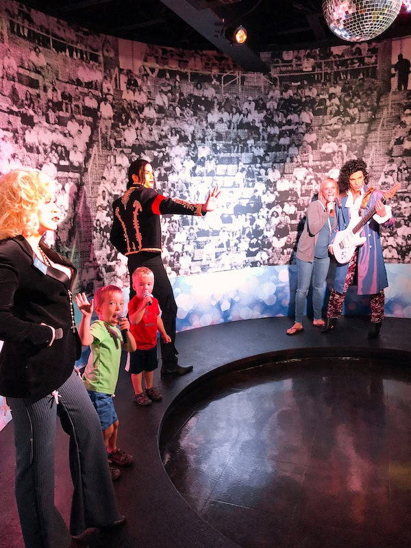 Mom and kids posing with life-size musician figures including Michael Jackson and Prince at the Hollywood Wax Museum in Branson, Missouri.