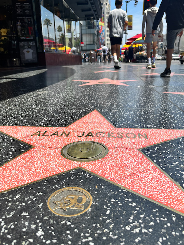 Alan Jackson's star on the Hollywood Walk of Fame with visitors walking along Hollywood Boulevard in Los Angeles.