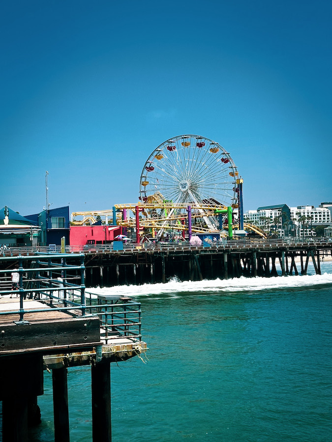 Pacific Park Ferris wheel and amusement rides on the Santa Monica Pier overlooking the Pacific Ocean in California.