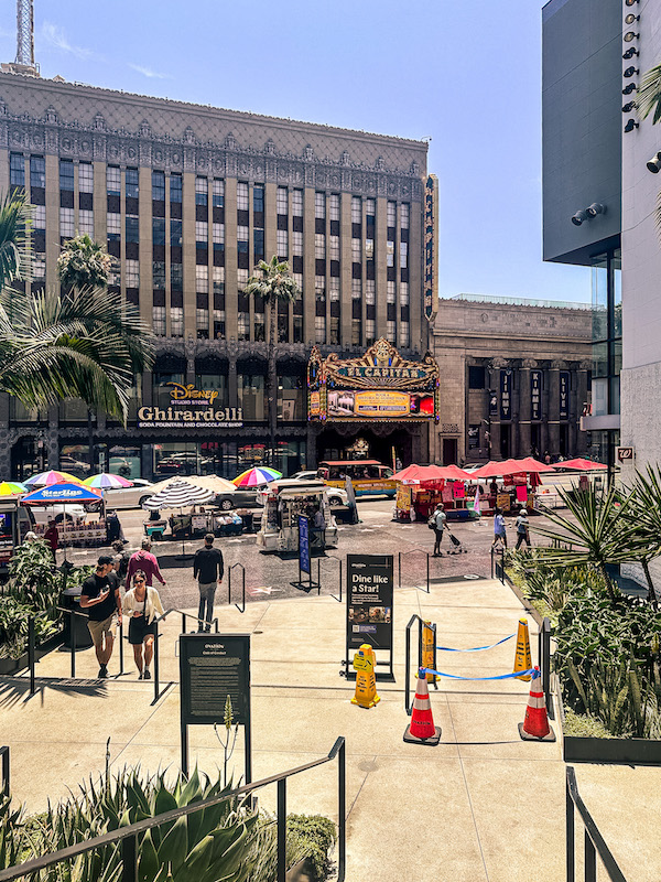 View from Ovation Hollywood overlooking Hollywood Boulevard, the El Capitan Theatre, shops, restaurants, and pedestrians exploring the area.