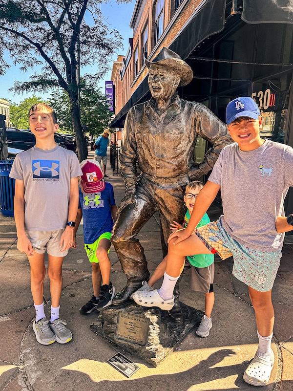 Children posing with the Ronald Reagan bronze statue from the City of Presidents walking tour in downtown Rapid City, South Dakota.
