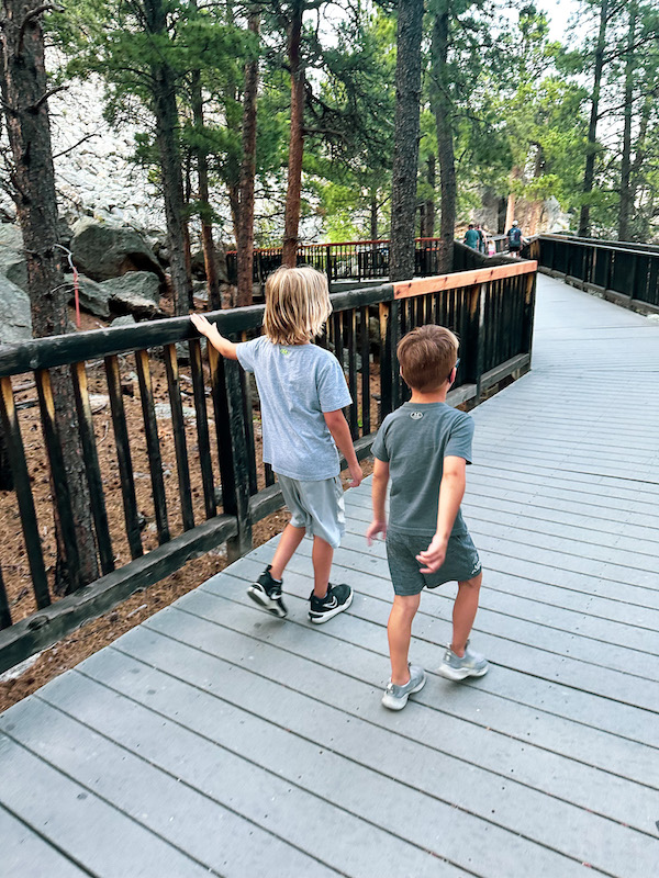Two children walking along the boardwalk on the Presidential Trail at Mount Rushmore National Memorial.