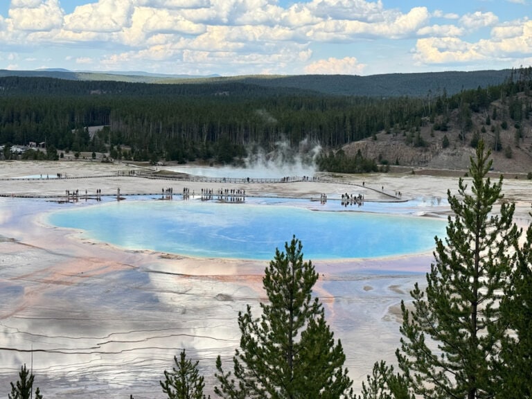 Grand Prismatic Spring viewed from the overlook, showing its bright blue center, colorful edges, steam, and surrounding boardwalks in Yellowstone National Park.